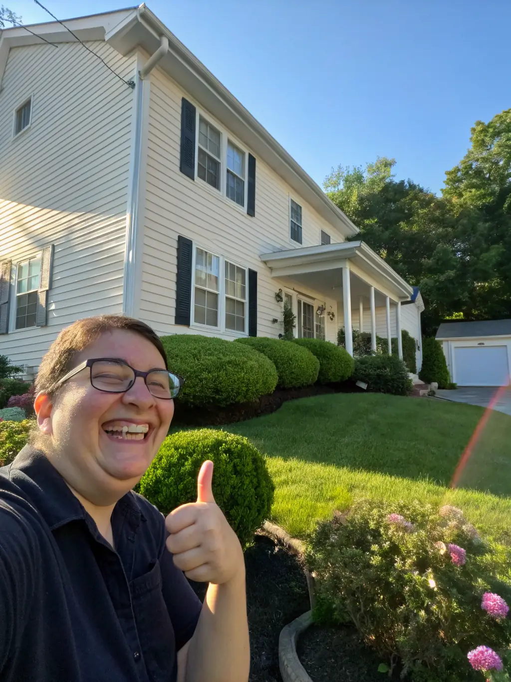 A customer giving a thumbs up after a power washing service, symbolizing satisfaction and positive experience with The Foam Theory.